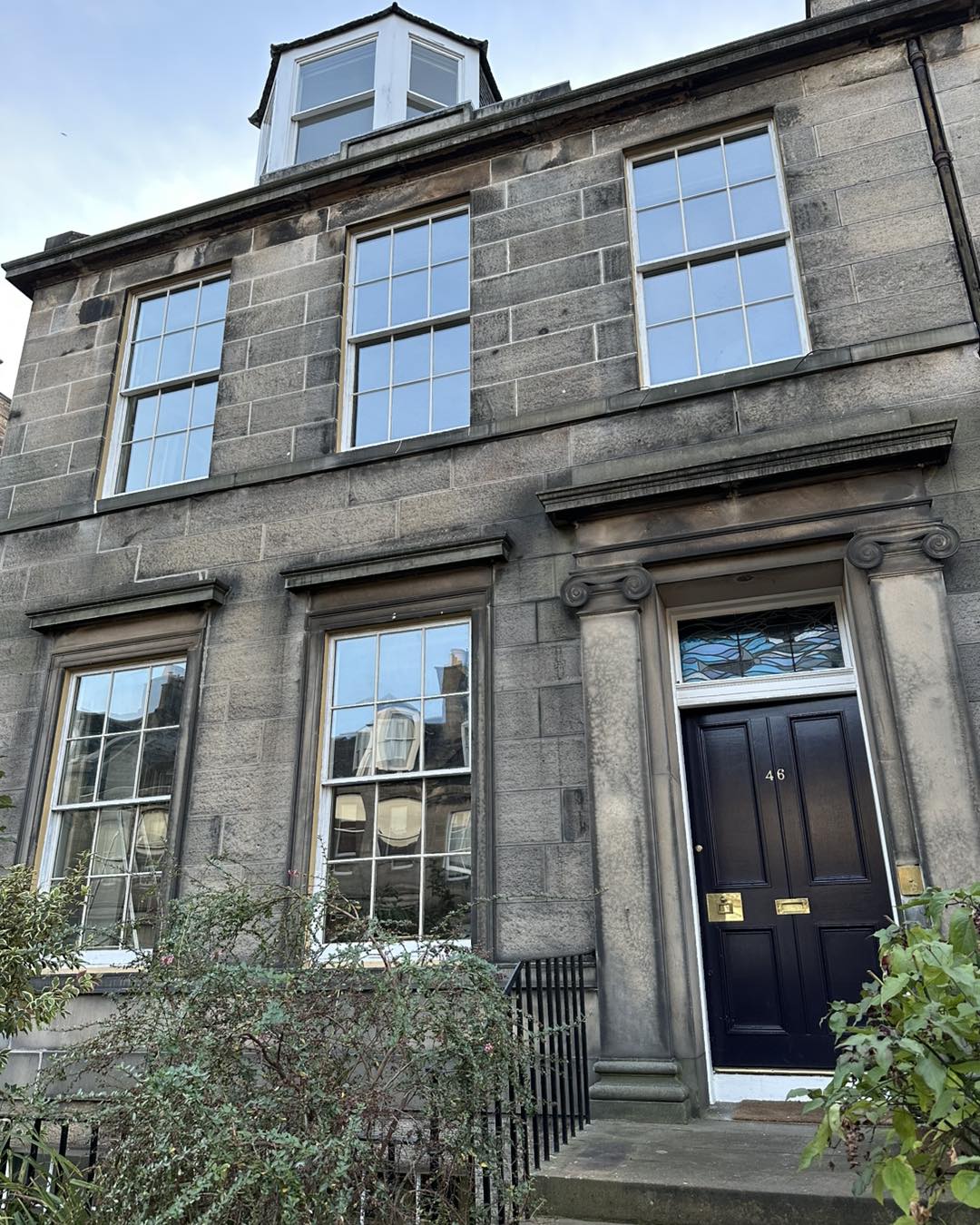 Large rectangle Sash windows on house building with black front door