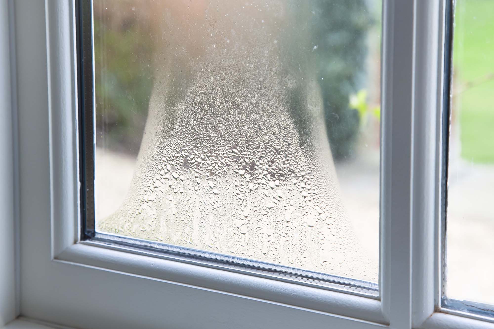 Blown double glazed unit, failed window glazing. Close up of blown double glazed unit. Failed window glazing with condensation inside, UK